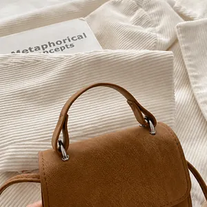 Close-up of caramel leather handbag handle with metallic silver hardware details