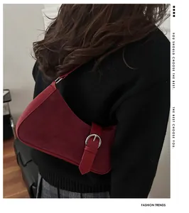 Gros plan d'un sac hobo bordeaux avec boucle décorative et détails en daim doux