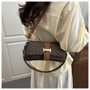 Detail of vintage patterned crossbody bag with gold buckle and adjustable strap