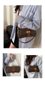 Detail of vintage monogram shoulder bag with gold clasp and brown leather texture