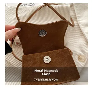 Close-up of the silver magnetic hardware snap and premium leather lining on a retro bag