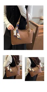 Close-up of brown leather tote bag featuring contrast stitching and a silk scarf accent