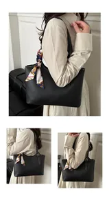 Detail of black tote bag featuring white stitching and a floral silk scarf on the handle
