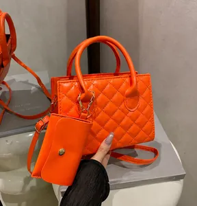 Dettaglio della borsa trapuntata arancione con mini pochette e manico rotondo elegante