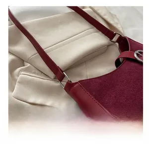 Detailed close-up of dark red suede shoulder bag with elegant silver metal ring hardware