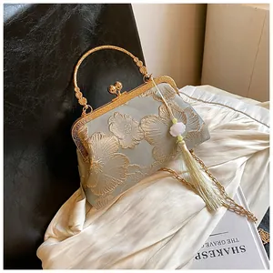 Details der eleganten chinesischen Stickerei und Goldgriff auf hellgrüner Seidentasche