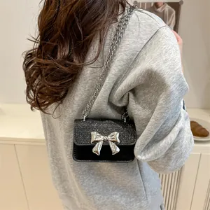 Black sequin mini shoulder bag with silver bow accent and delicate chain strap for women