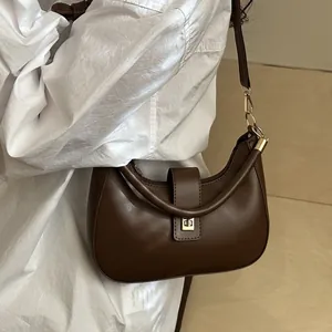 Deep brown crescent moon shoulder bag with unique ring handle and golden metal clasp