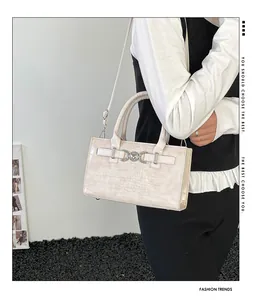 Lifestyle shot of cream crocodile pattern handbag with silver heart buckle and strap