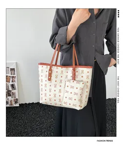 Detail of white tote bag with bear monogram print and matching small zipper pouch
