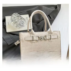Close-up of cream crocodile pattern handbag with silver heart buckle and metal hardware