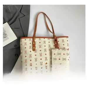 Close-up of vintage monogram tote bag set including a small pouch and gold hardware