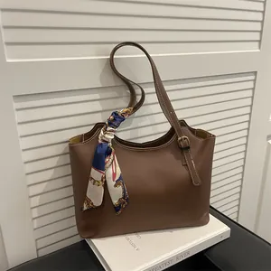 Brown leather tote bag with vintage printed silk scarf handle and white stitching detail