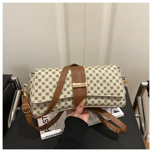 Detail of vintage geometric print handbag with brown leather strap and gold buckle