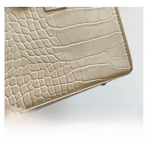 Macro shot of apricot crocodile pattern leather texture with fine stitching and studs