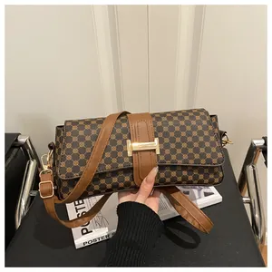 Close-up of vintage brown geometric print handbag with gold buckle and leather strap