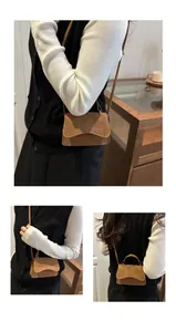 Detail of a brown suede mini crossbody bag featuring a unique wavy flap and top handle