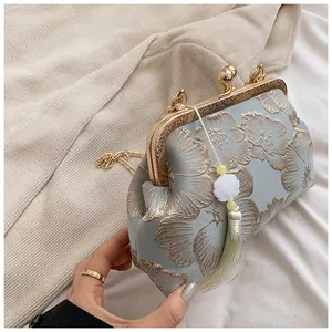 Nahaufnahme der Vintage-Jacquard-Abendtasche mit goldenem Rahmen und Seidenquaste-Detail