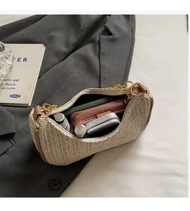 Spacious interior of beige straw crescent bag with thick metal chain and daily essentials