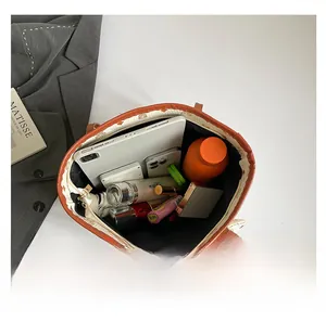 Top-down view of a spacious beige tote bag showing tablet and cosmetics inside