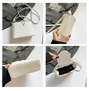 Details van witte handtas met lychee-textuur, V-vormige gesp en binnencompartiment