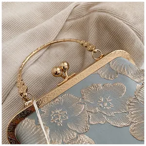 Detailansicht der Blumenstickerei und des goldenen Kussverschlusses an der Seiden-Clutch