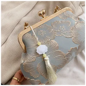 Detail der hellblauen Abendtasche aus Seide mit Goldstickerei und Quastenanhänger