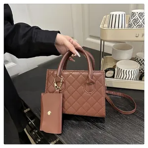 Dettaglio borsa a mano marrone trapuntata con pochette rimovibile e finiture dorate
