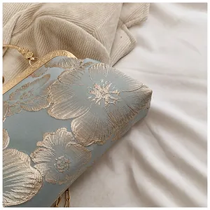 Detailansicht hellblaue Abendtasche aus Seide mit Goldstickerei und Metallverschluss