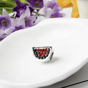 Dettaglio macro dello charm anguria con cristalli rossi e verdi per bracciali DIY
