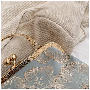 Detail der Vintage-Brokattasche mit goldener Blumenstickerei und Klippverschluss