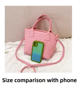 Pink woven leather boston bag size comparison with a mobile phone for scale