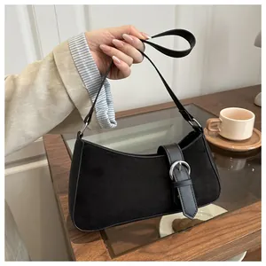 Detail of black patchwork shoulder bag with silver buckle and smooth leather straps