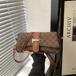 Vintage brown monogram handbag for women with a prominent gold H-shaped buckle