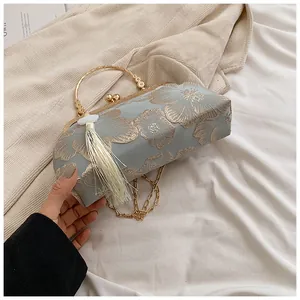Detailansicht der blauen Stofftasche mit Goldstickerei, Perlenverschluss und Quaste