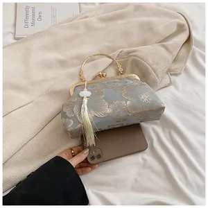 Detailansicht der hellblauen Stickerei Abendtasche mit goldenen Quasten und Ringgriff