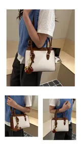Detail of white and brown leather crossbody bag with cherry charm and fashion text