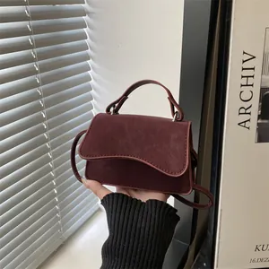 Burgundy PU leather mini handbag with wavy flap design and slim shoulder strap