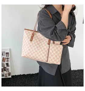 Fashionable large tote bag set with monogram print and brown leather handles on model