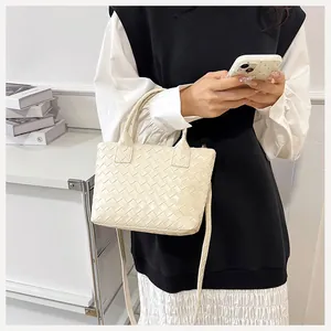 Macro detail of creamy white woven leather texture on a vintage Boston shoulder bag