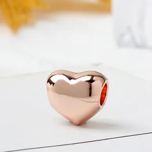 Detailed view of heart-shaped rose gold charm with mirror-polished finish and side hole