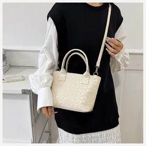 Detailed view of the beige woven texture and soft PU leather on this tote bag