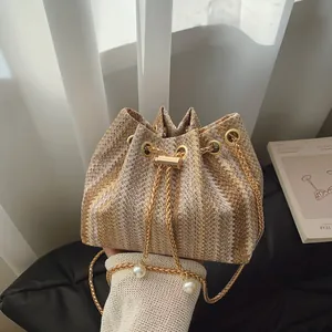 Straw bucket bag with zigzag patterns, golden chain strap and pearl drawstring accents