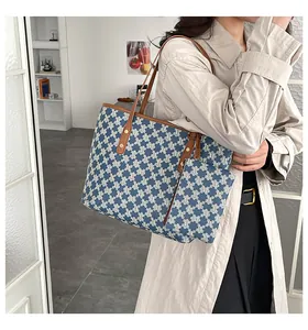 Detail of blue canvas tote and small pouch set with M-pattern and brown leather straps