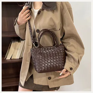Detail of deep brown woven shoulder bag with intricate texture and adjustable strap