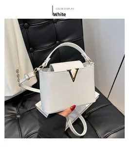 Detail van witte lederen handtas met gouden V-logo en verstelbare schouderband