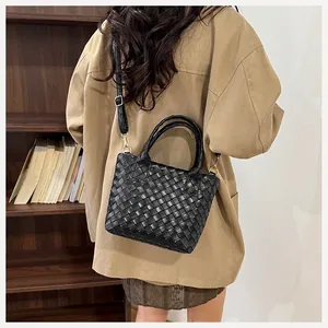 Detail shot of black woven hobo bag with gold hardware and removable leather strap