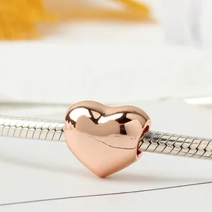 Polished rose gold heart charm bead on silver snake chain bracelet for women