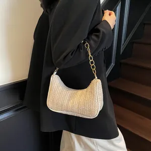 Chic beige woven crescent bag with gold chain strap on model in stylish setting