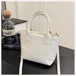 Detail of white woven texture leather handbag with circular handles and shoulder strap